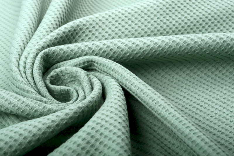Piqué is a knit fabric with raised waffle or honeycomb textures.